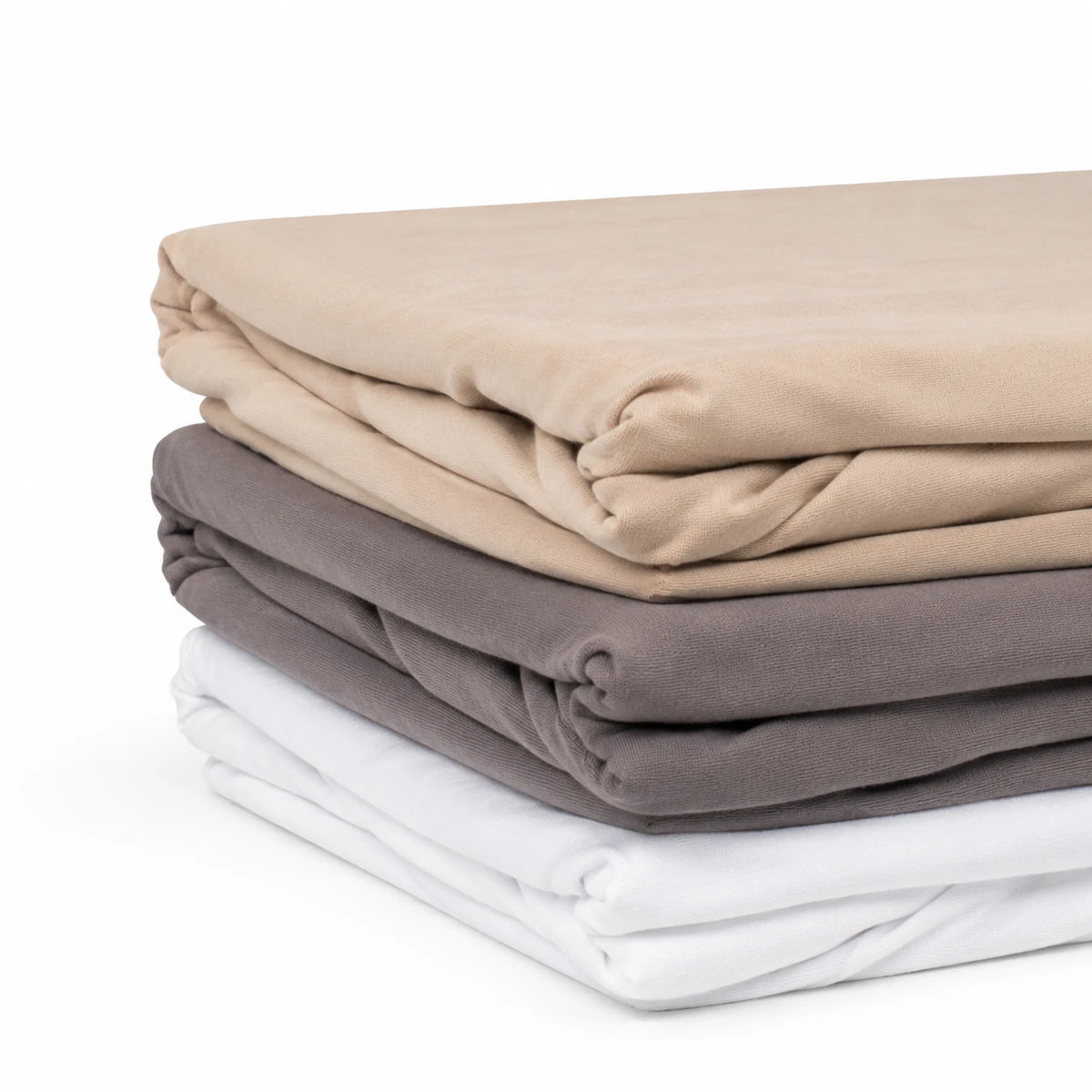 Trois draps housse en coton pliés : beige, taupe et blanc