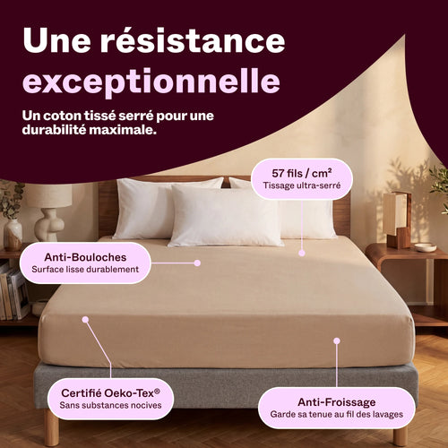 Drap housse en coton beige sur un lit dans une chambre chaleureuse, tissage 57 fils/cm²
