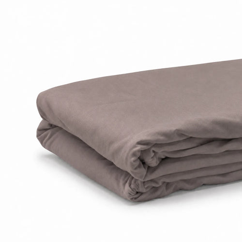 Drap housse en coton taupe plié, fond blanc
