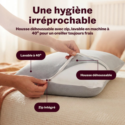 Mains ouvrant la housse zippée déhoussable de l'oreiller, lavable à 40°