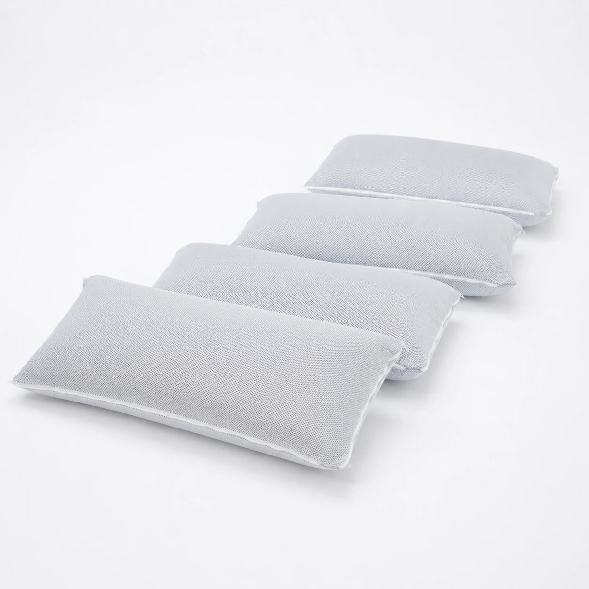 Quatre oreillers à mémoire de forme alignés, fond blanc