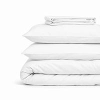 Parure de lit en coton blanc pliée : housse de couette, taies et drap housse