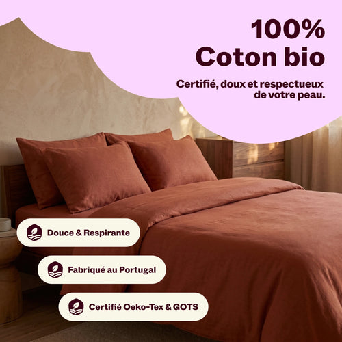 Parure de lit en coton bio couleur terracotta sur un lit, certifiée Oeko-Tex et GOTS
