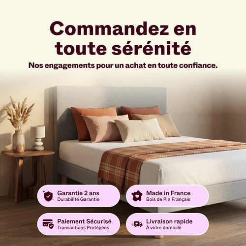 Tête de lit grise dans une chambre, lit fait avec coussins terracotta et plaid